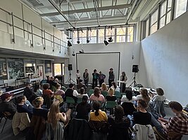 Das Publikum der Abschlussveranstaltung und Personen auf der Bühne