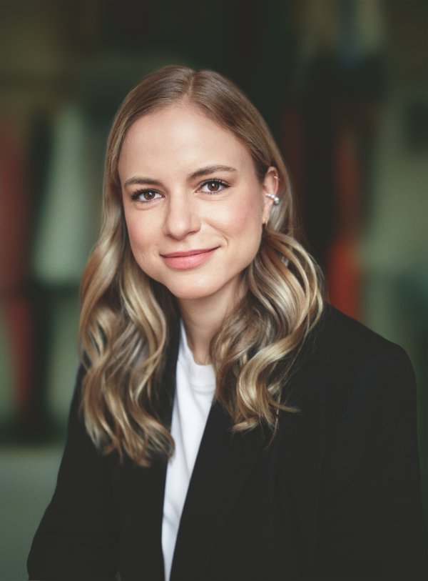 Portrait der Autorin Julia Engelmann. Sie trägt einen schwarzen Cardigan, gewellte Haare und lächelt.