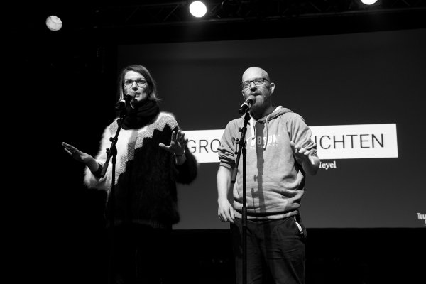 Pauline Füg und Tobias Heyel auf der Bühne bei einem vergangenen Poetry-Slam. Bild in schwarz-weiß.