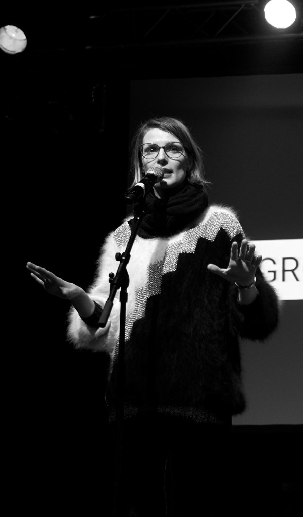 Pauline Füg auf der Bühne bei einem vergangenen Poetry-Slam. Bild in schwarz-weiß.