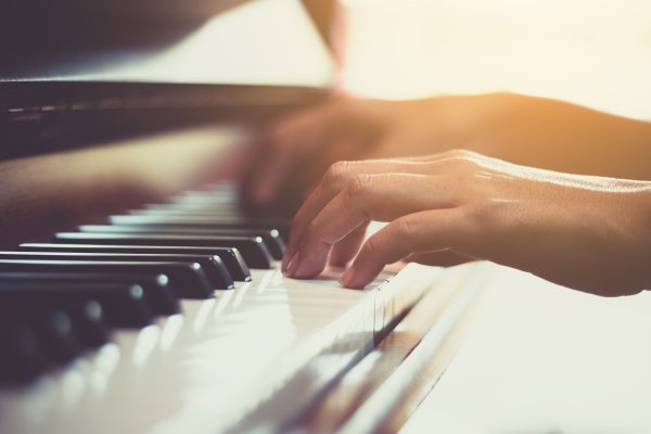 Close up of happy woman's hand playing the piano in the morning.