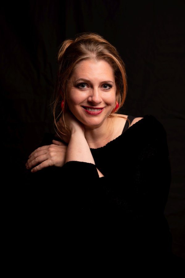 Porträt der Erzählerin, mit roten Ohrringen, lächelt in Kamera