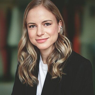 Portrait der Autorin Julia Engelmann. Sie trägt einen schwarzen Cardigan, gewellte Haare und lächelt.